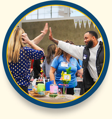 Teachers at a conference exchange a high-five